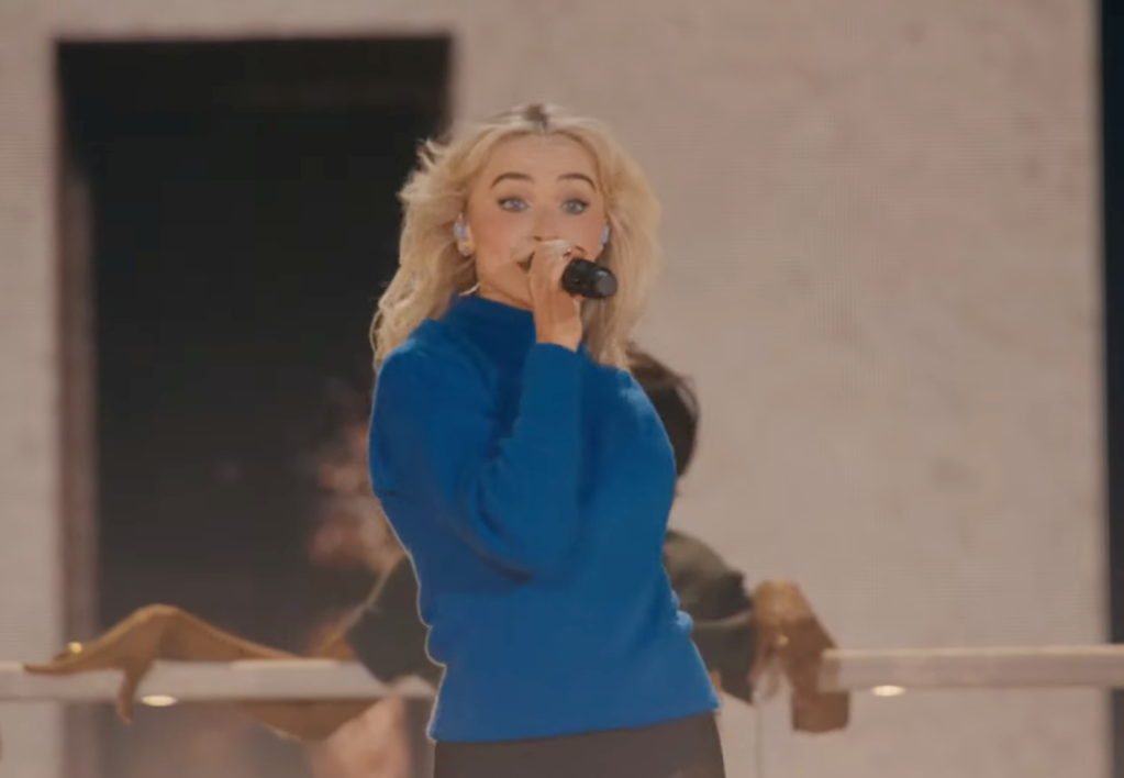 Sabrina Carpenter singing into a microphone on stage at Coachella.