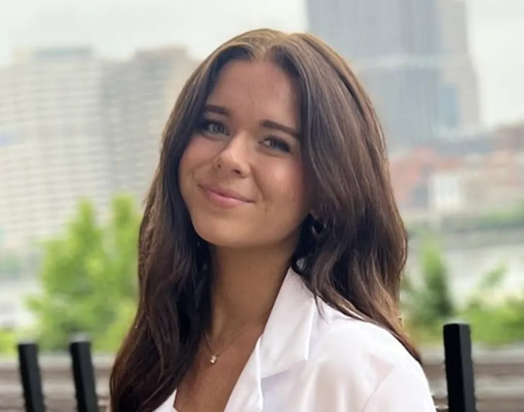 Woman with long brown hair smiling.