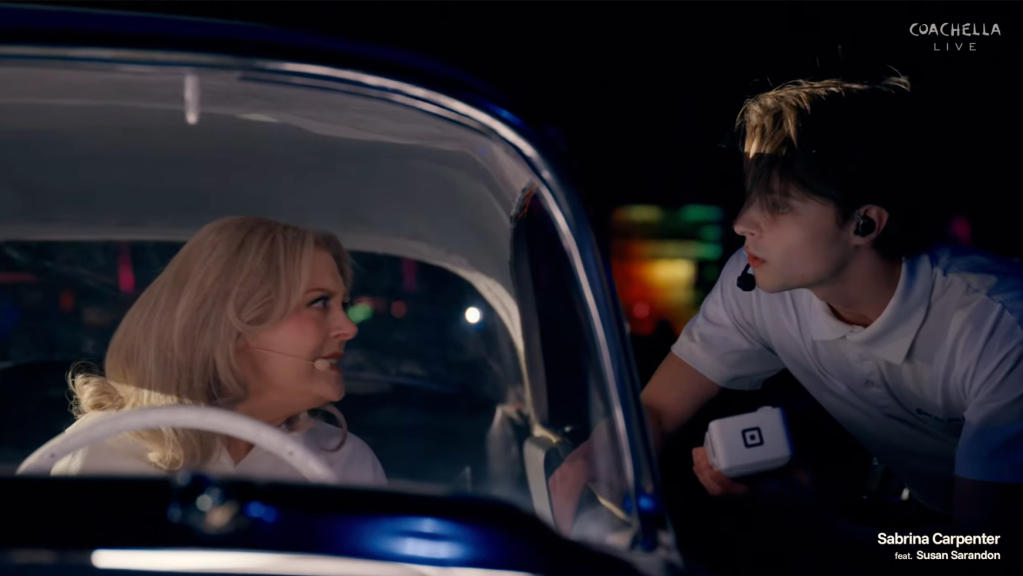 Susan Sarandon in a car talking to a young man through the car window.