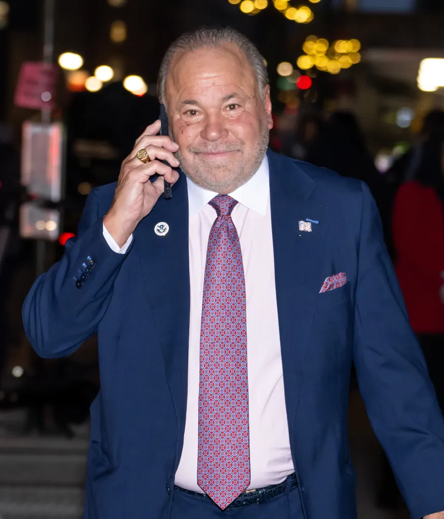 Actor Bo Dietl seen outdoors wearing a suit and tie, talking on a cell phone.