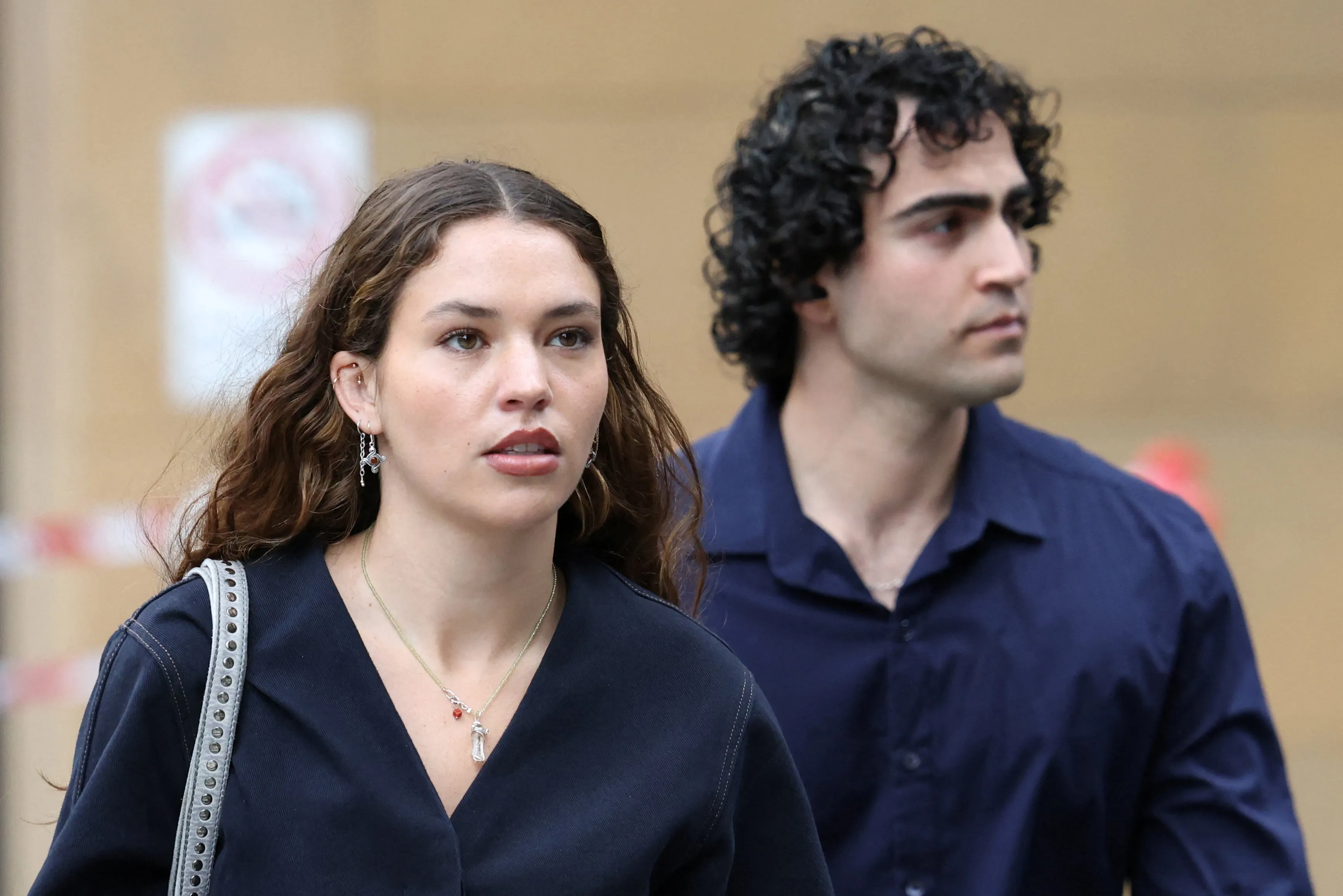 Actor Charlotte MacInnes arrives at court on the first day of a nine-day defamation hearing in Sydney, accompanied by a man.