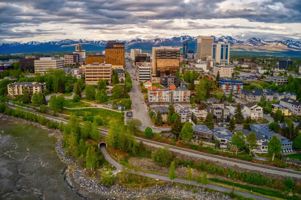 Aerial view of downtown Anchorage, Alaska, with mountains in the background.