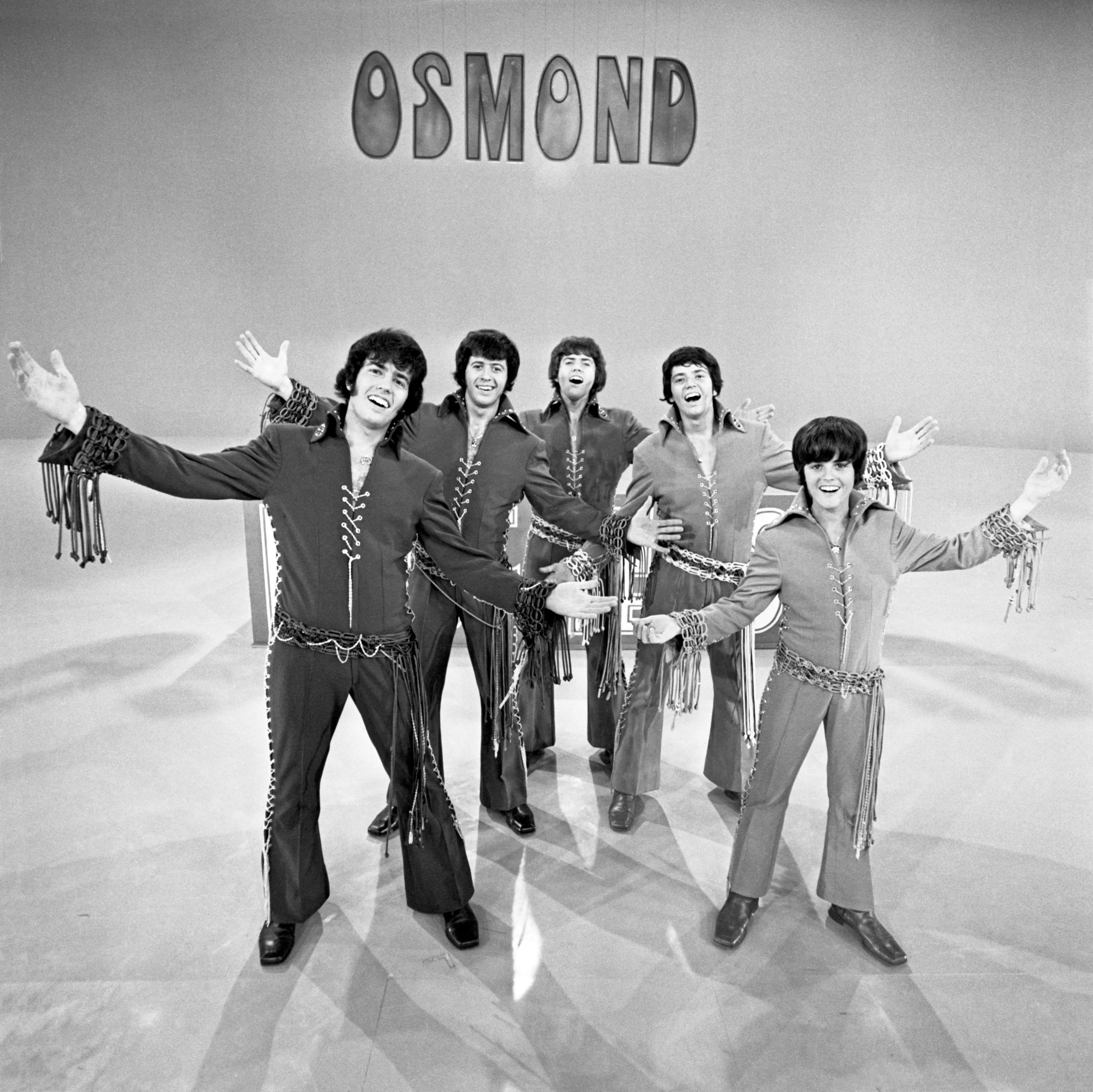 The Osmond Brothers (Alan, Wayne, Merrill, Jay, and Donny) posing on a stage during The Osmond Brothers Special.