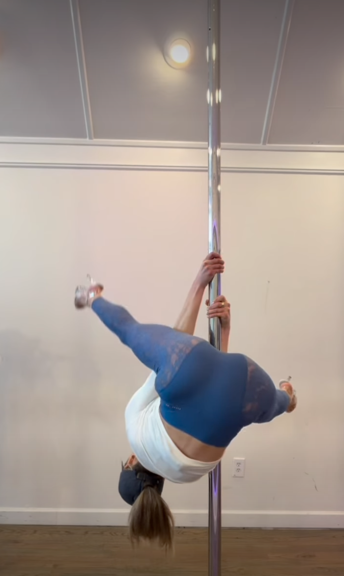 Alix Earle pole dancing upside down.