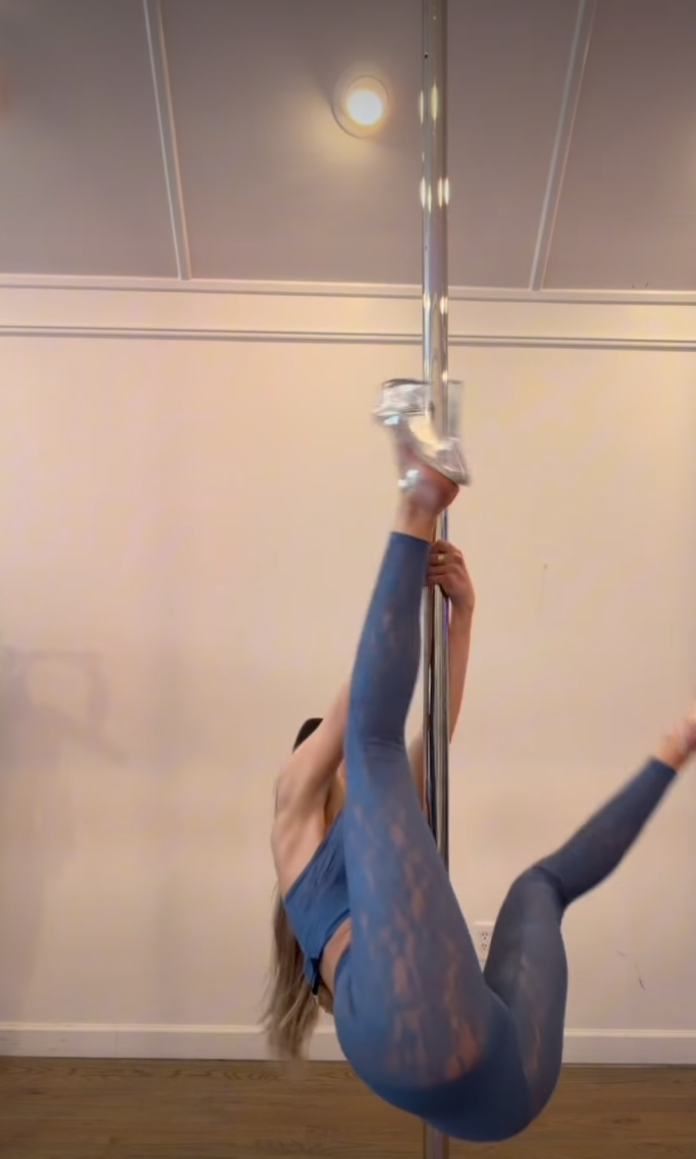 Alix Earle pole dancing in blue athletic wear and silver platform heels.