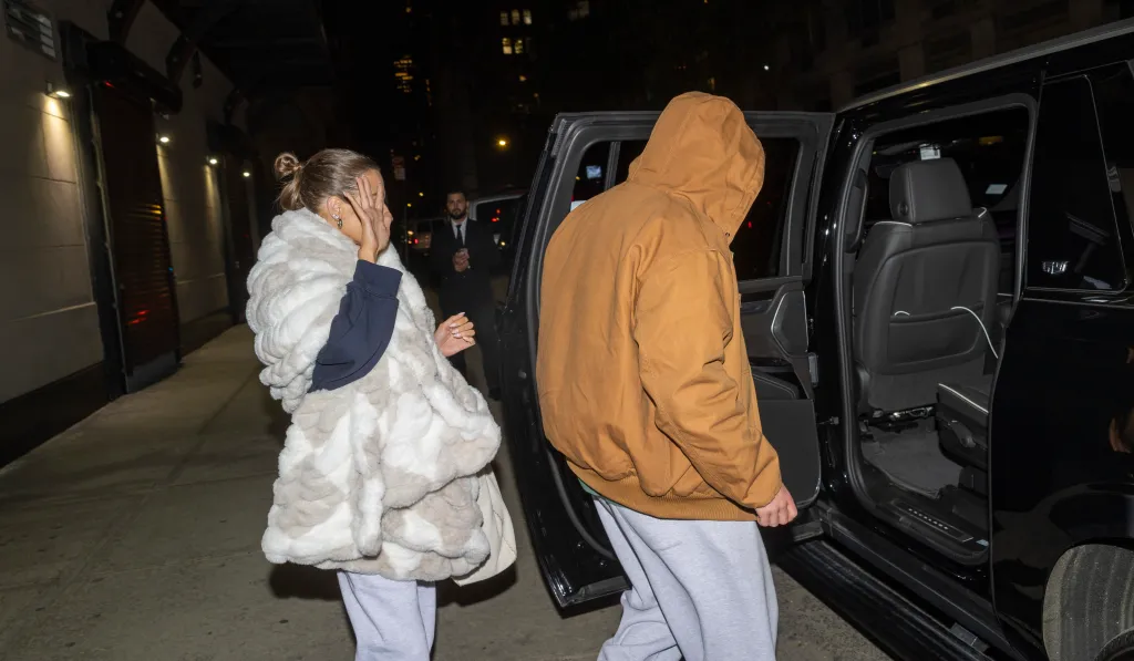 Amanda Batula covers her face and West Wilson enters a black SUV.