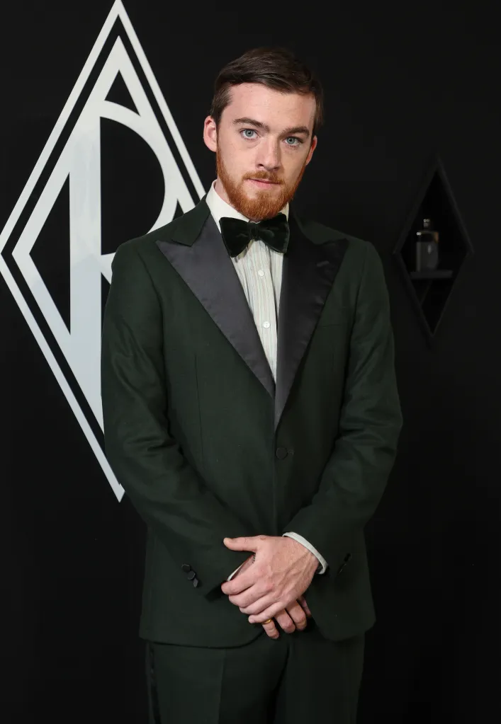 Angus Cloud in a dark green suit, light pinstripe shirt, and dark green velvet bow tie.