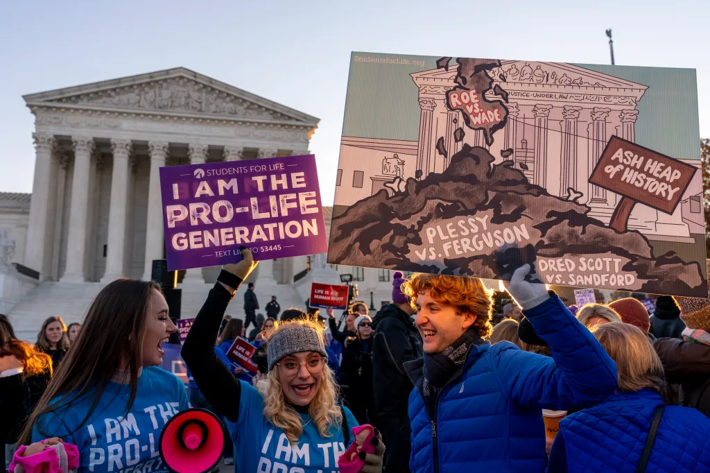 Anti-abortion protesters hold signs in front of the US Supreme Court building.