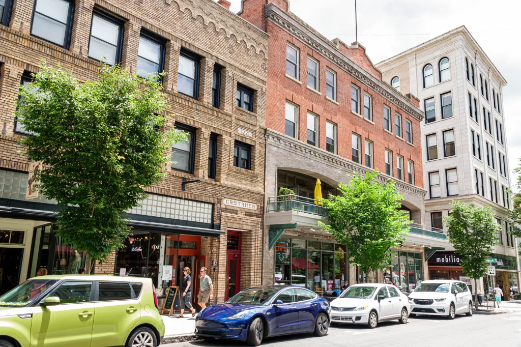 Street scene in downtown Asheville, North Carolina, with businesses and parked cars.
