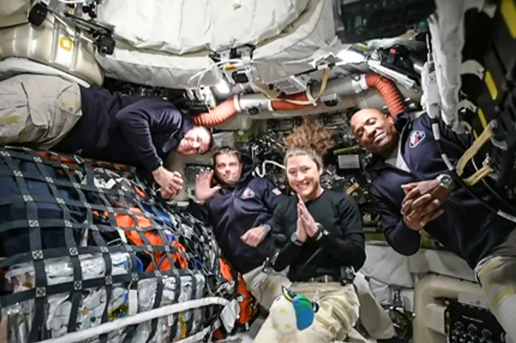 The four Artemis II crew members pose for a photo inside a spacecraft.