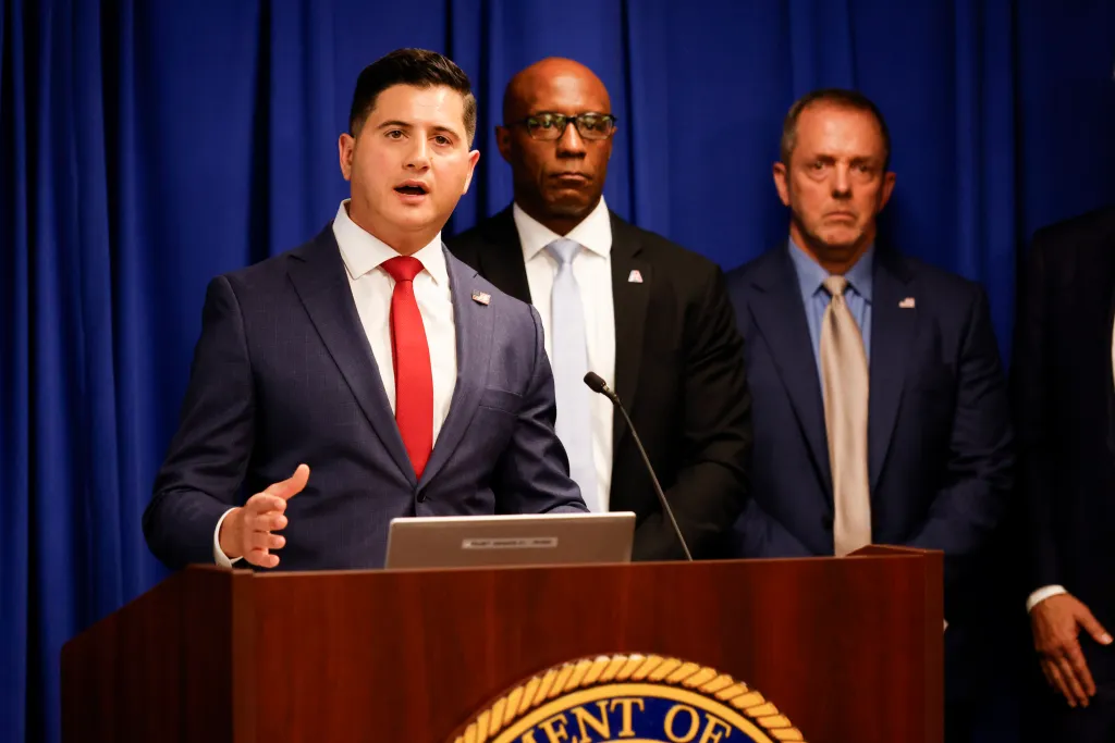 Bill Essayli speaking at a press conference about fraud in California.
