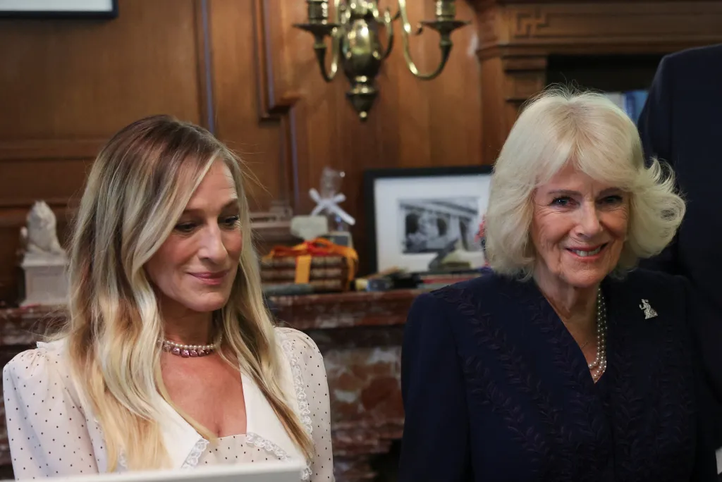 Queen Camilla, in a navy blue dress, and Sarah Jessica Parker, in a cream dress, at a literary event in New York City.