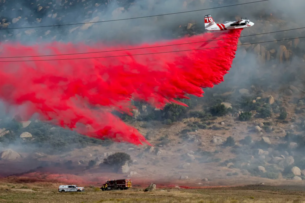 A Cal Fire tanker drops fire retardant while battling the Springs Fire.