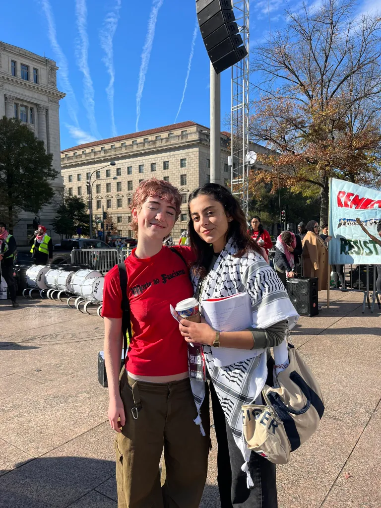 Two young women pose at a march for Palestine.