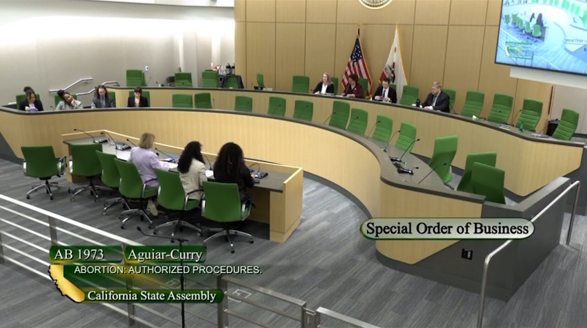 A legislative meeting is in session, where California State Assembly bill AB 1973, concerning abortion authorized procedures, is being discussed as a special order of business.