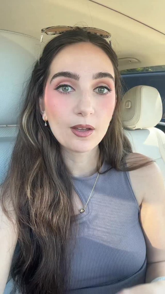Cheyenne Hunt wearing sunglasses on her head and a ribbed tank top, sitting in a car.