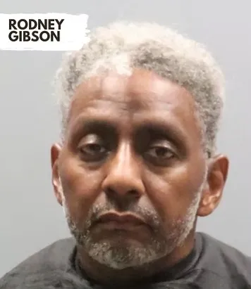 Mugshot of Rodney Gibson, a man with light skin, graying hair, and a goatee, wearing a dark top.