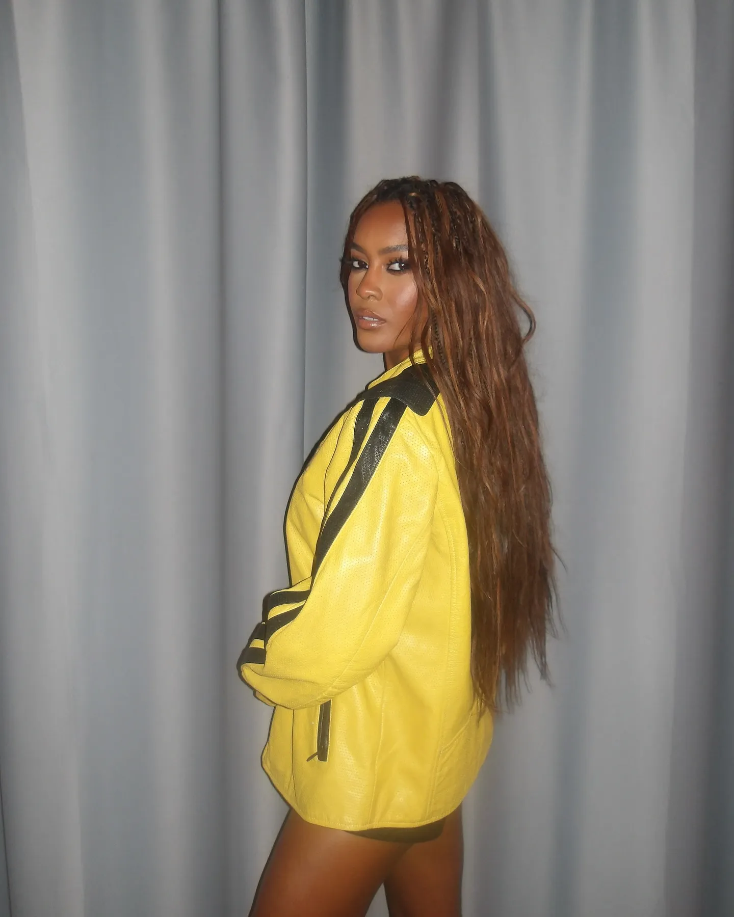 Ciara Miller in a yellow jacket with black stripes.