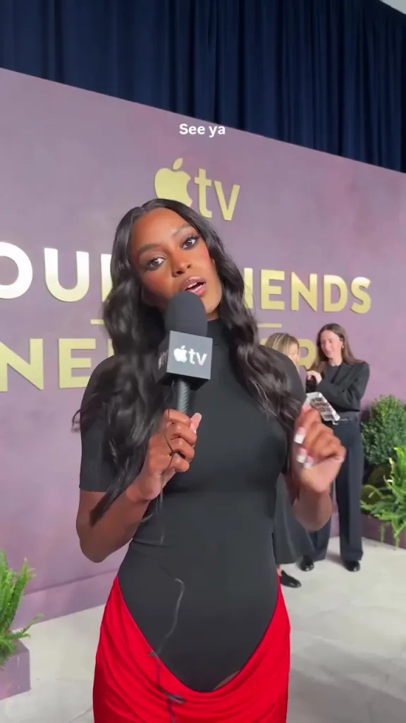 Ciara Miller holding an Apple TV+ microphone at an event.