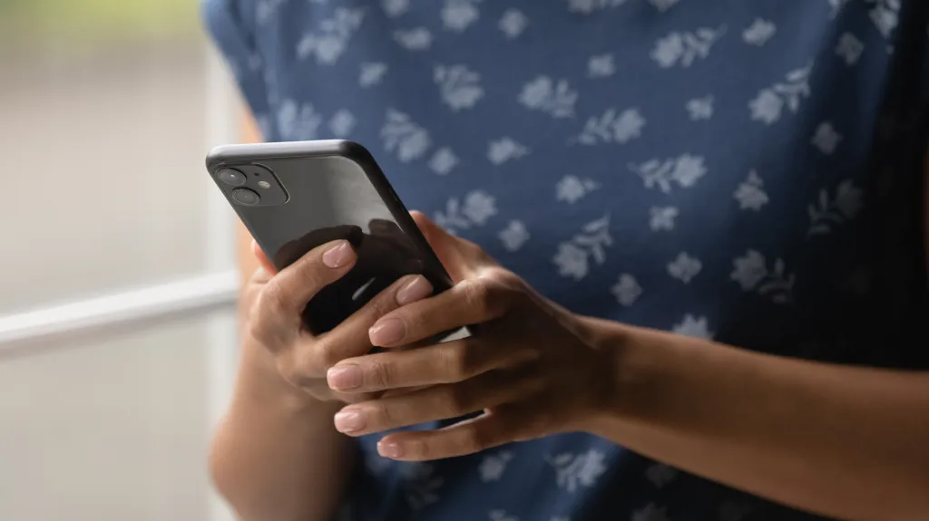 Close-up of a young African American woman holding a smartphone.