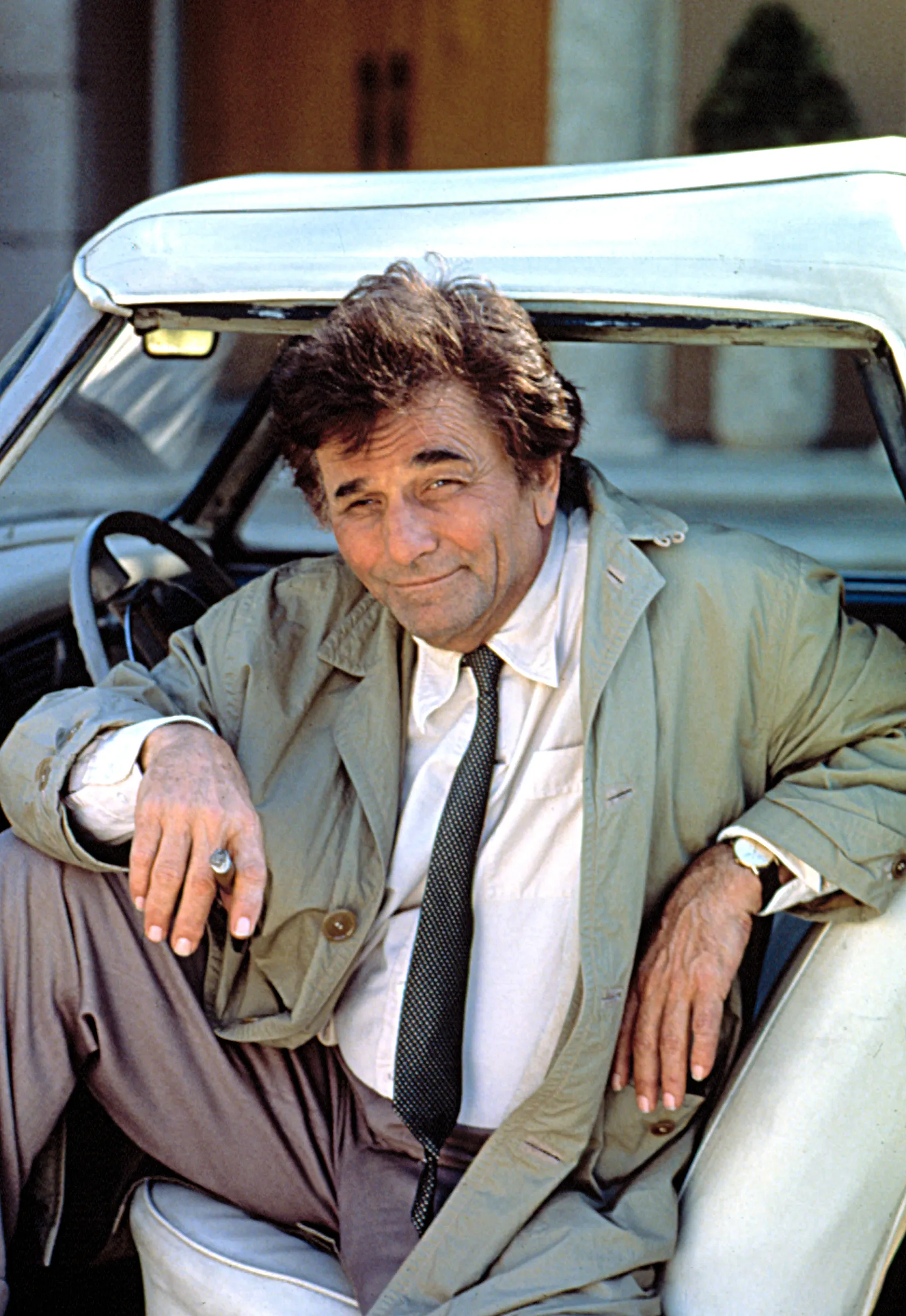 Peter Falk as Columbo sitting in his car with a cigar in his hand.