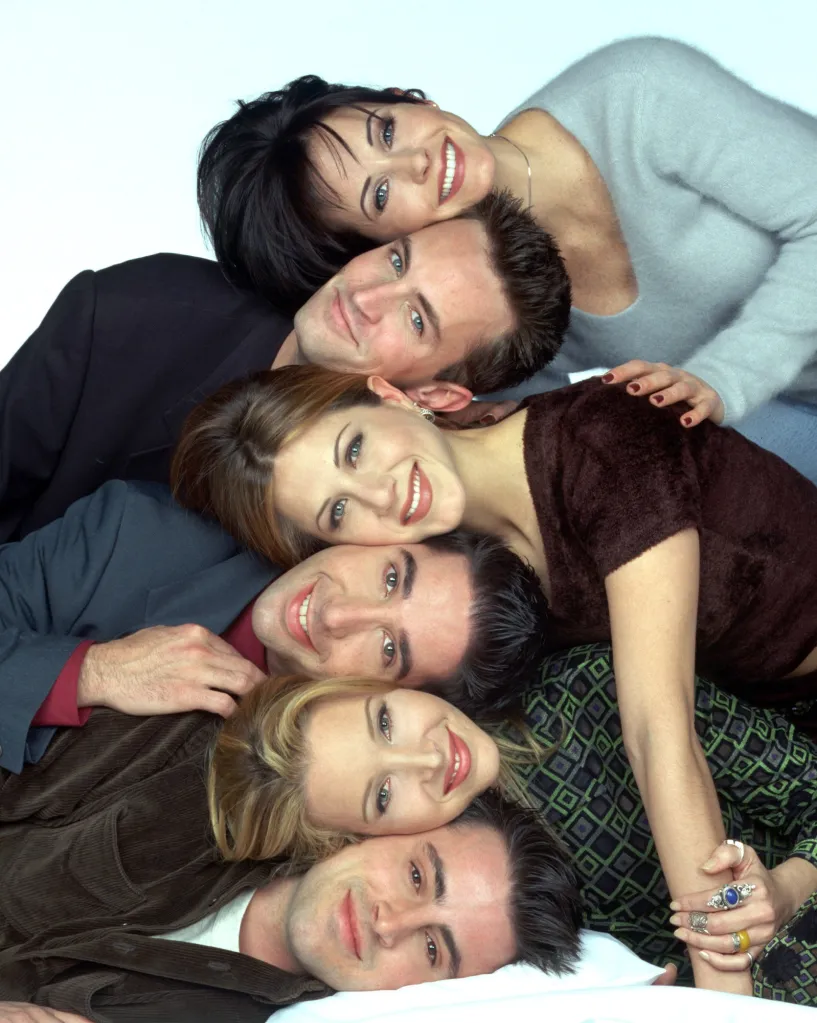 Six cast members of Friends, Courteney Cox, Matthew Perry, Jennifer Aniston, David Schwimmer, Lisa Kudrow, and Matt LeBlanc, lie stacked on top of one another.