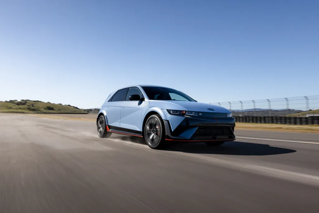 A light blue Hyundai IONIQ 5 N drives quickly on a race track, with its wheels blurred to suggest motion.