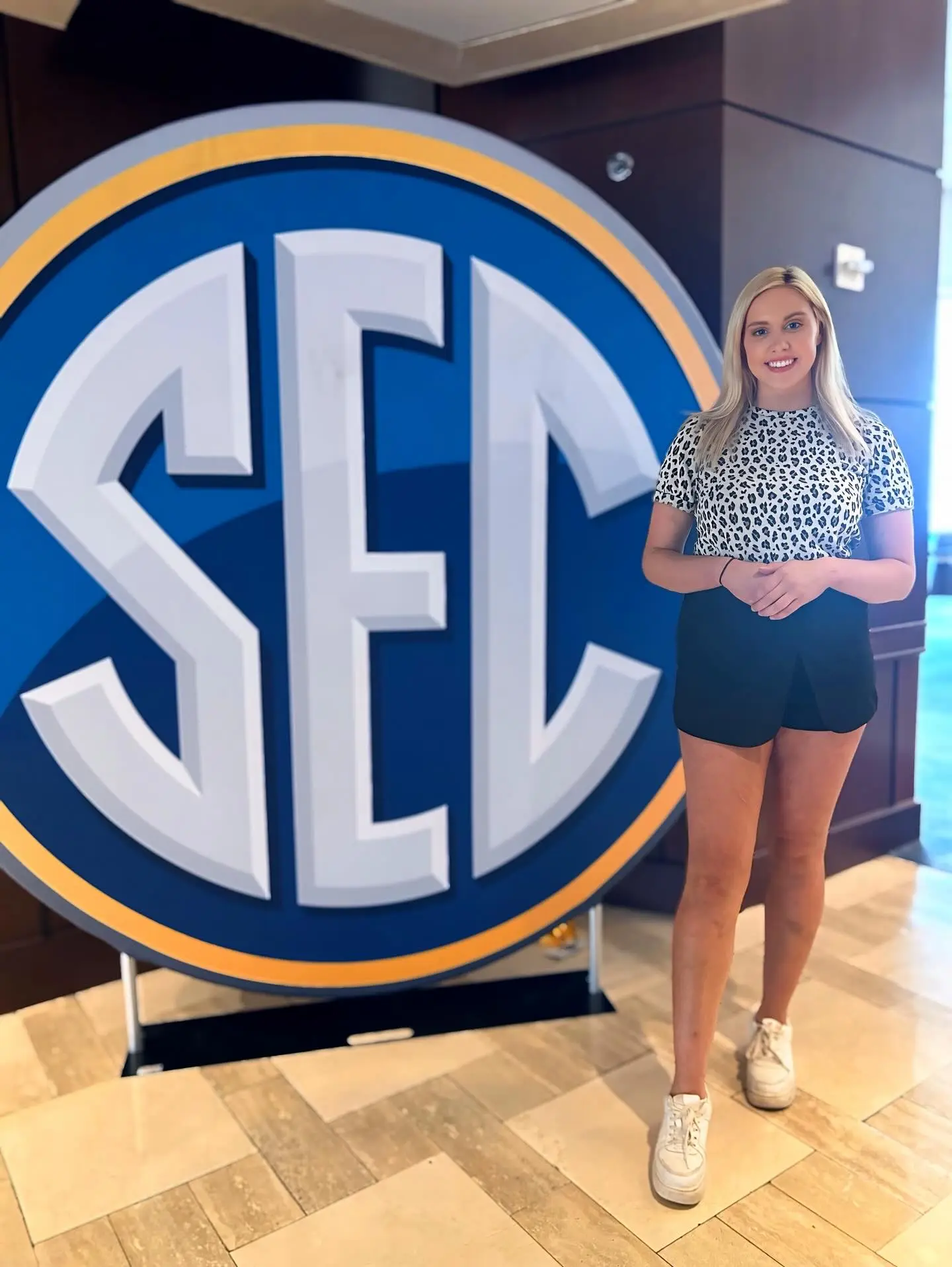 Crissy Froyd posing in front of an SEC logo.