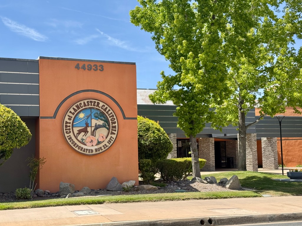 Lancaster City Hall building with a large circular seal for the City of Lancaster, California, next to the entrance.