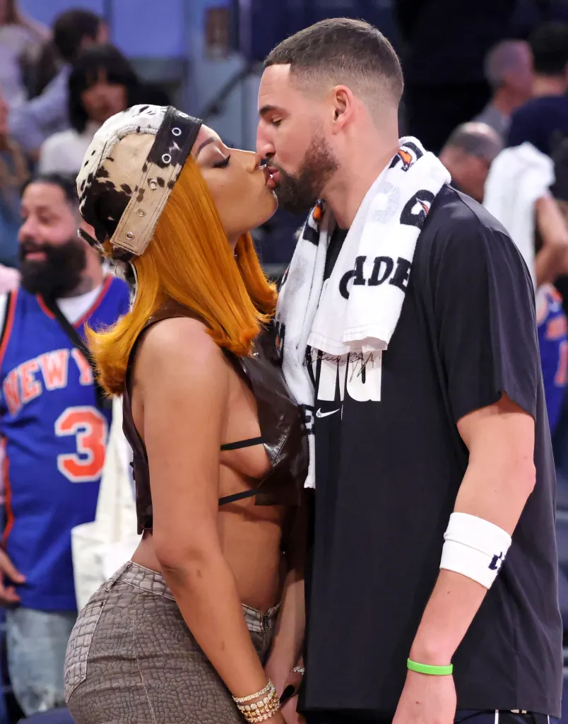 Music artist Megan Thee Stallion kisses Dallas Mavericks guard Klay Thompson after a game.