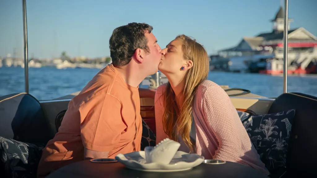 David and Abbey share a kiss on a boat.