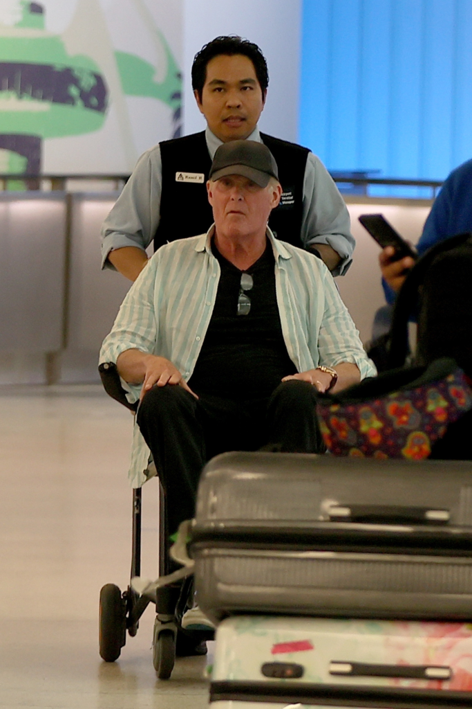 David Hasselhoff in a wheelchair pushed by an airport worker at LAX.
