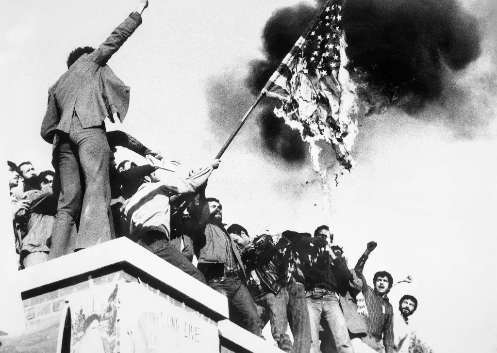 Iranian demonstrators burning an American flag on the U.S. Embassy wall in Tehran.