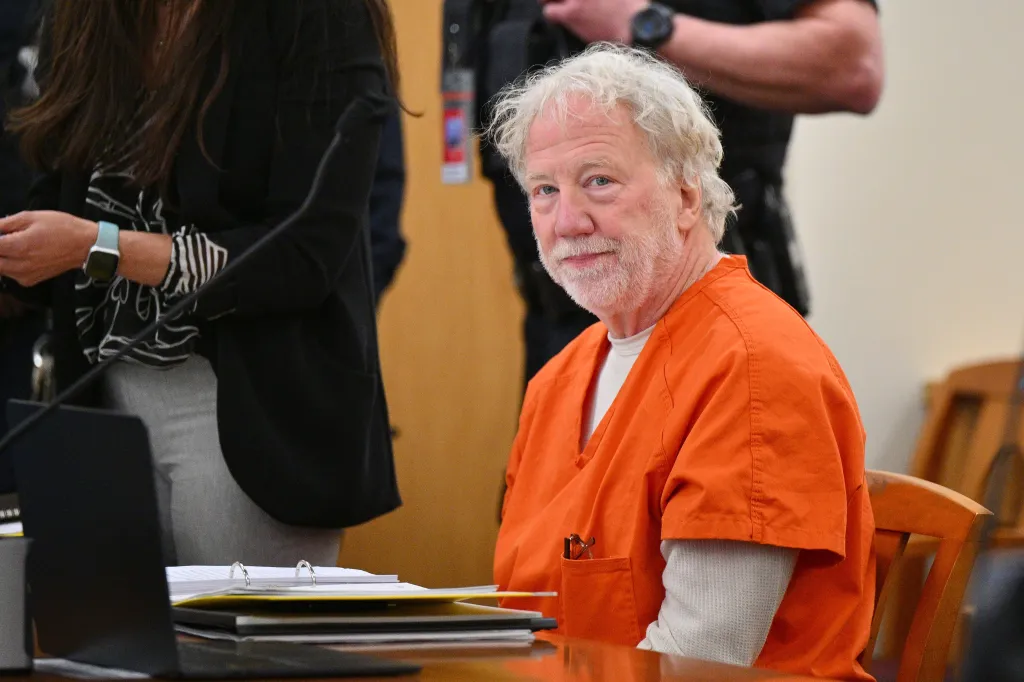 Timothy Busfield, in an orange jumpsuit, looks on during a court hearing.