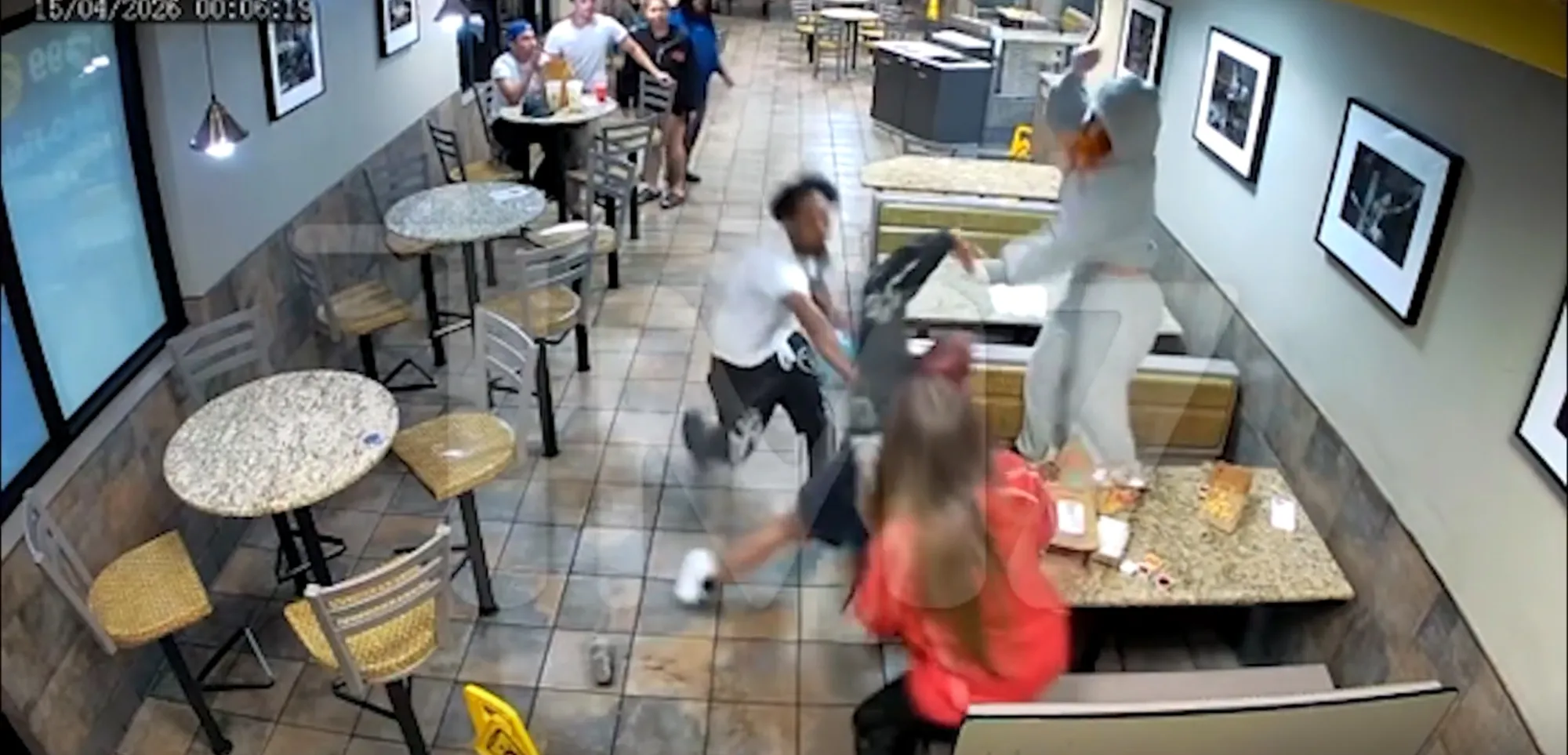Security footage shows a fight inside a McDonald's, with one person on a table, another kicking, and a third on the floor.