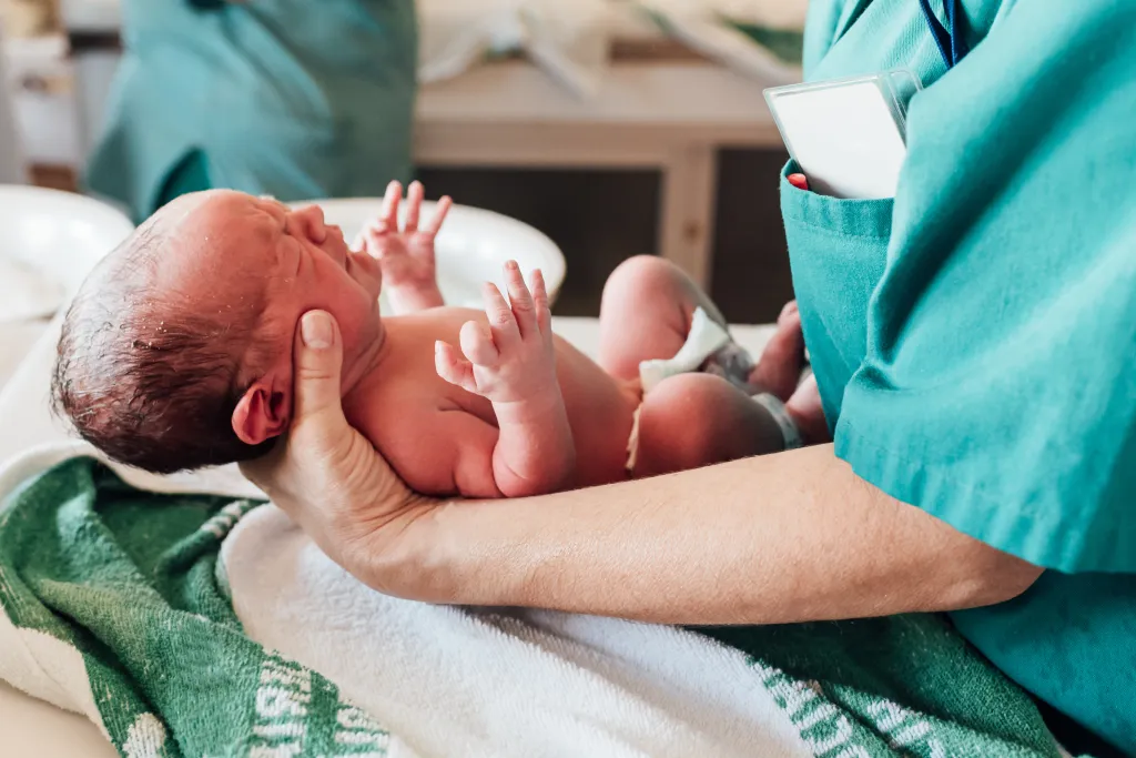 Doctor holding a newborn baby.