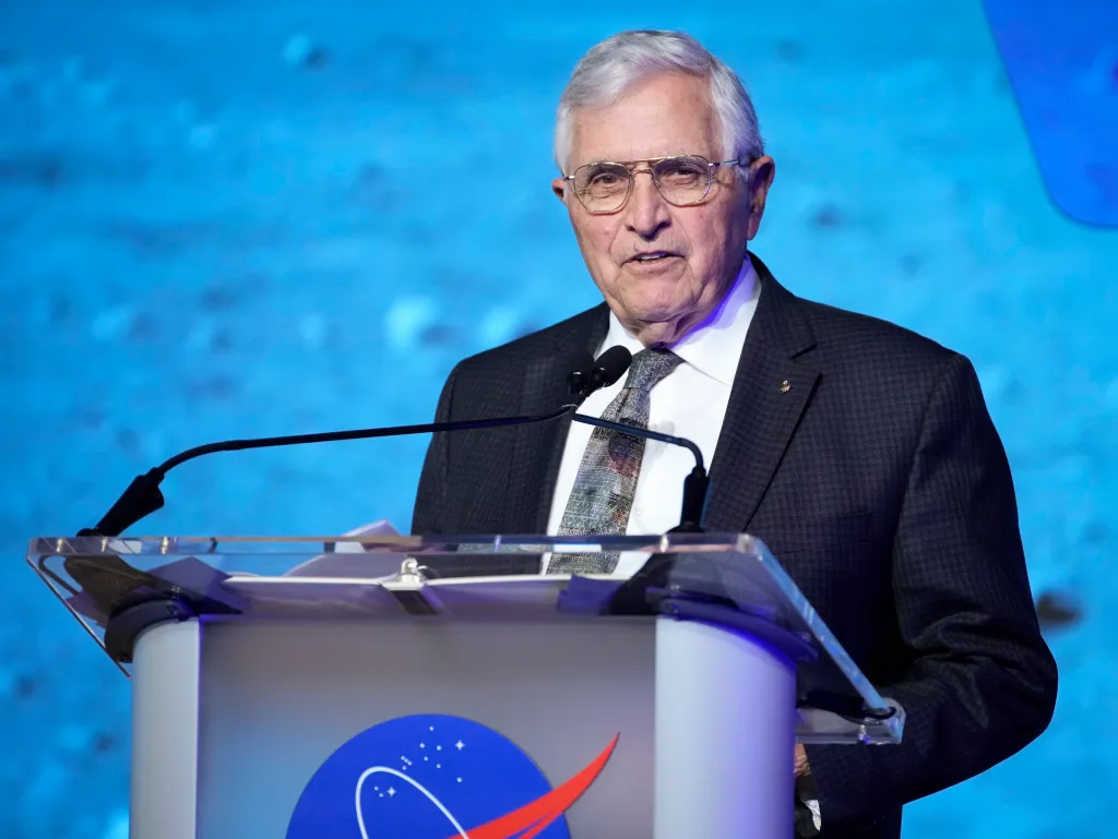 Dr. Harrison Schmitt, Apollo 17 astronaut, speaks at a podium with a NASA logo.