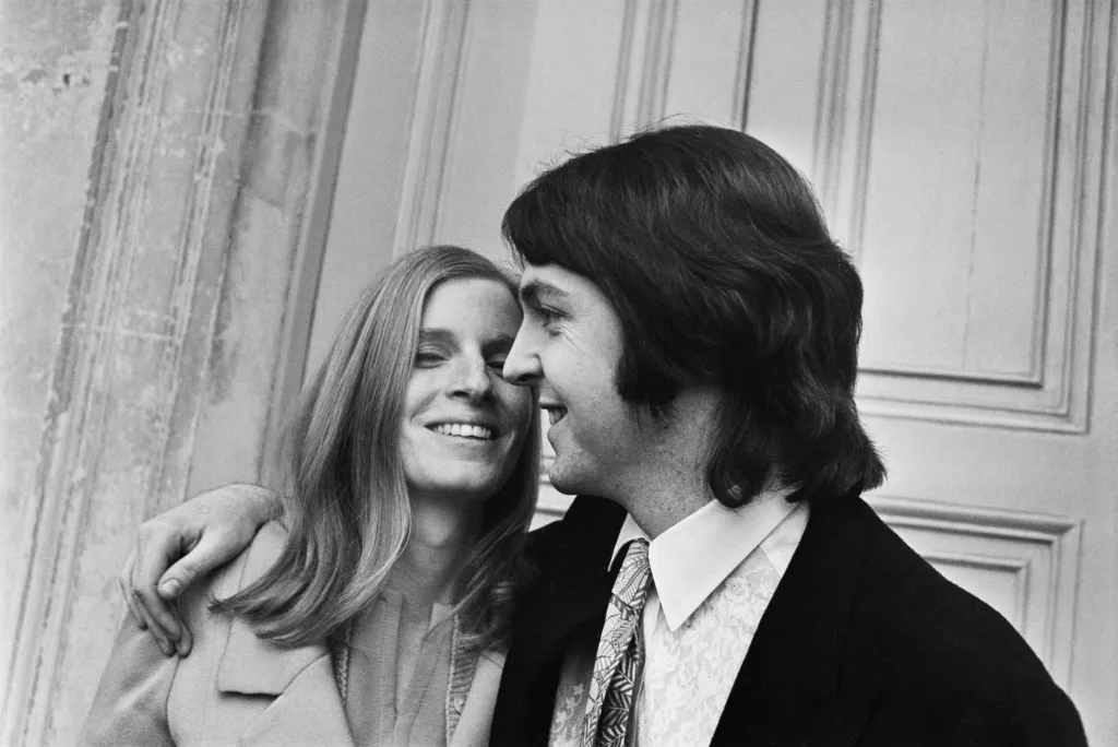 Paul McCartney with his arm around Linda Eastman on their wedding day.
