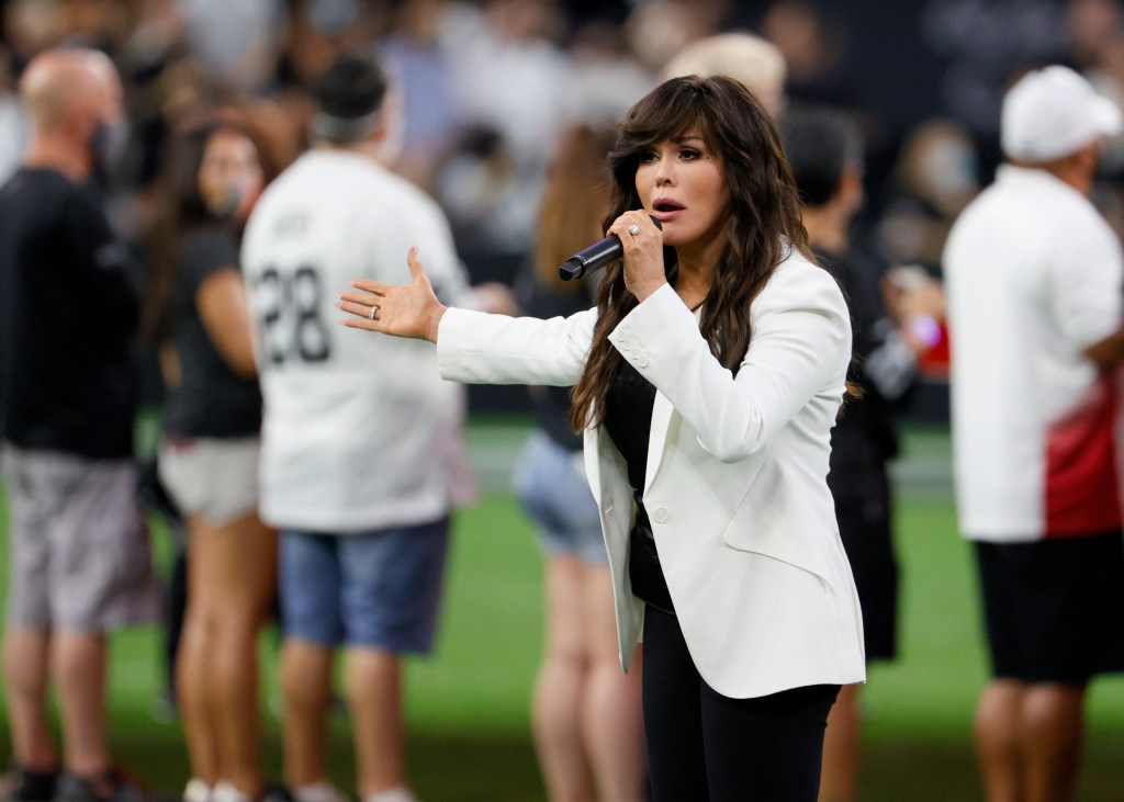 Entertainer Marie Osmond sings the American national anthem at a football game.