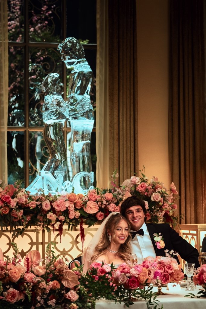 Sydney Sweeney and Jacob Elordi sitting at a wedding reception table.