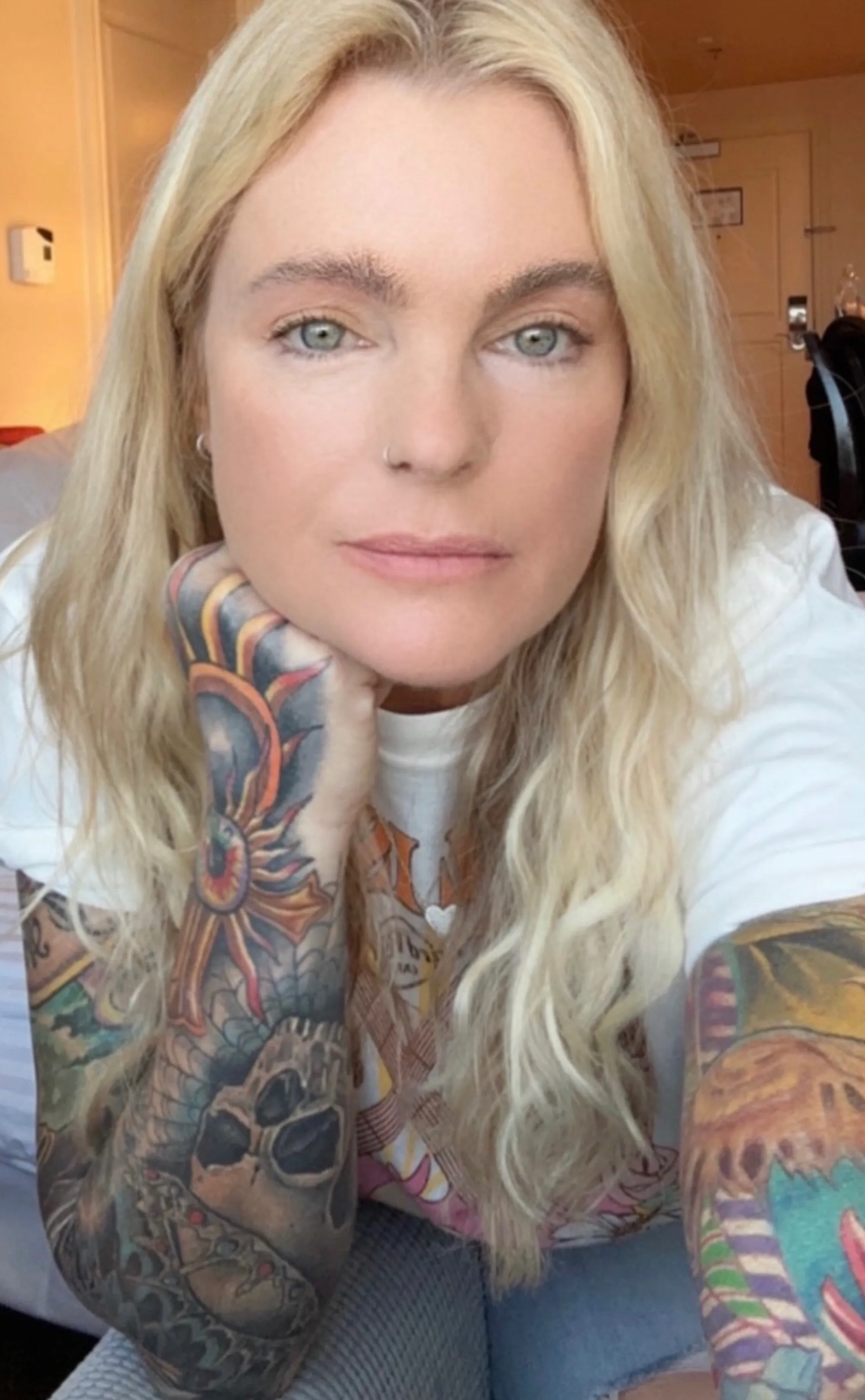 Erika Eleniak with full sleeve tattoos.
