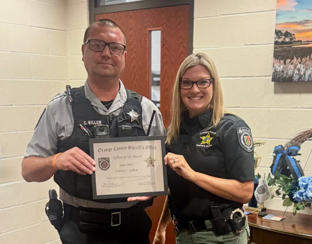 Two police officers, a man and a woman, holding up an 