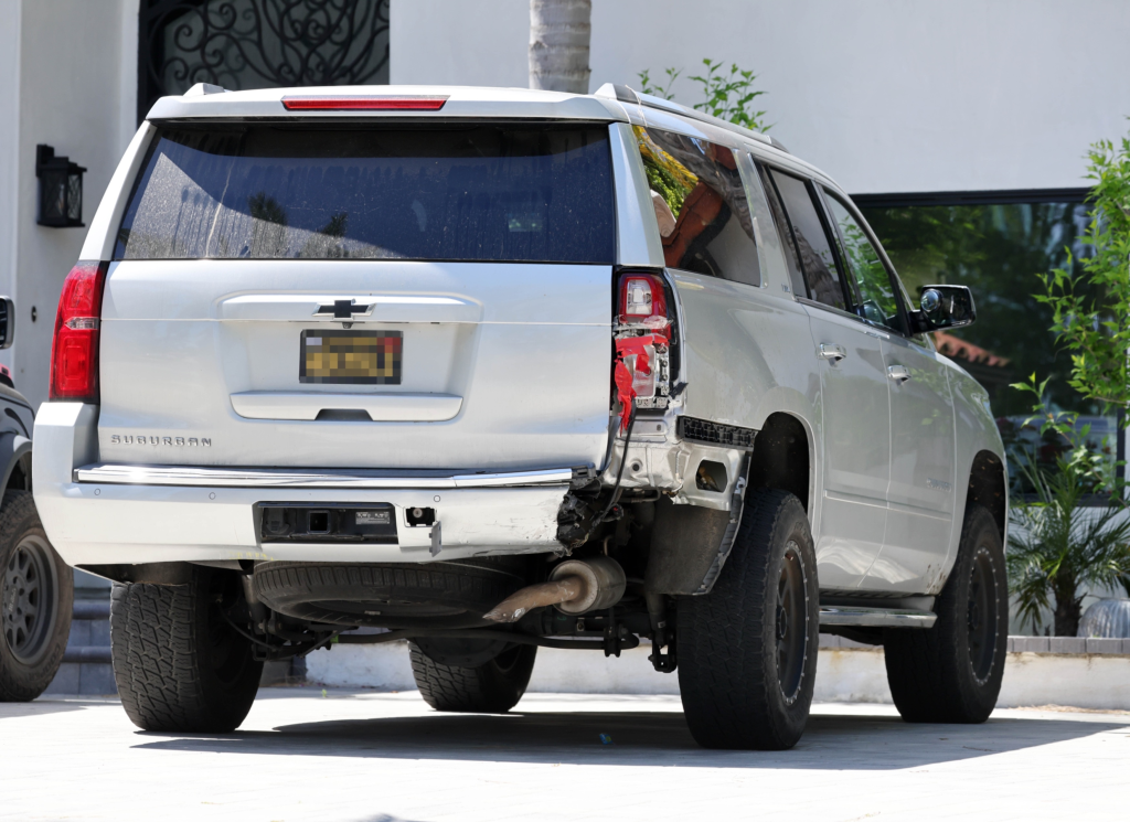 Rear view of Tori Spelling's damaged silver Chevrolet Suburban after a crash.