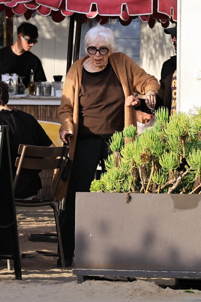 Shirley MacLaine stepping out for lunch in Malibu, assisted by another person.