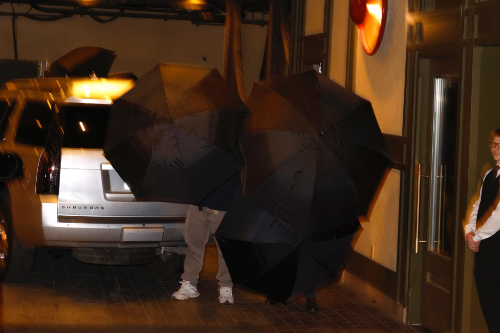Taylor Swift and Travis Kelce hiding behind umbrellas while arriving at Casa Cipriani in NYC.