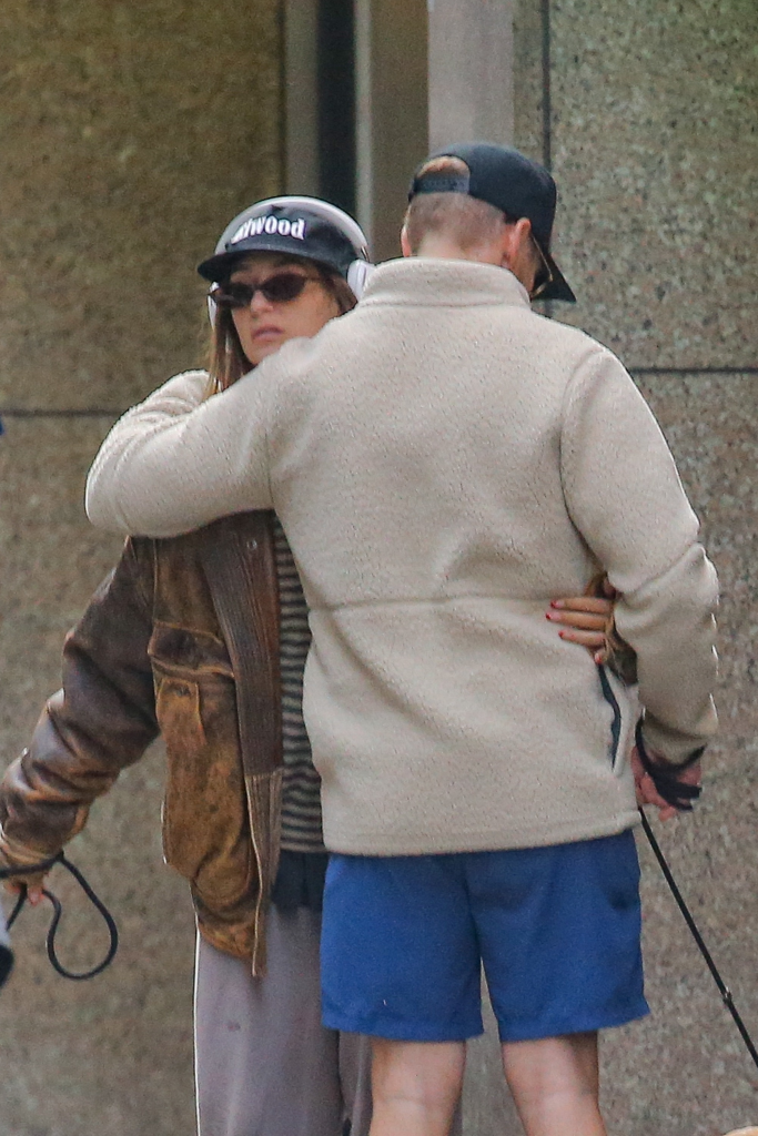Amanda Batula in a distressed leather jacket and Kyle Cooke in a beige fleece embracing on a New York City sidewalk.