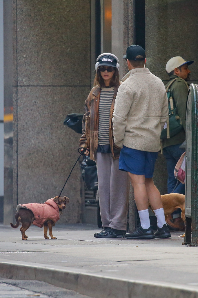 Amanda Batula and Kyle Cooke on a New York City street, both dressed casually, with Batula holding a dog on a leash.