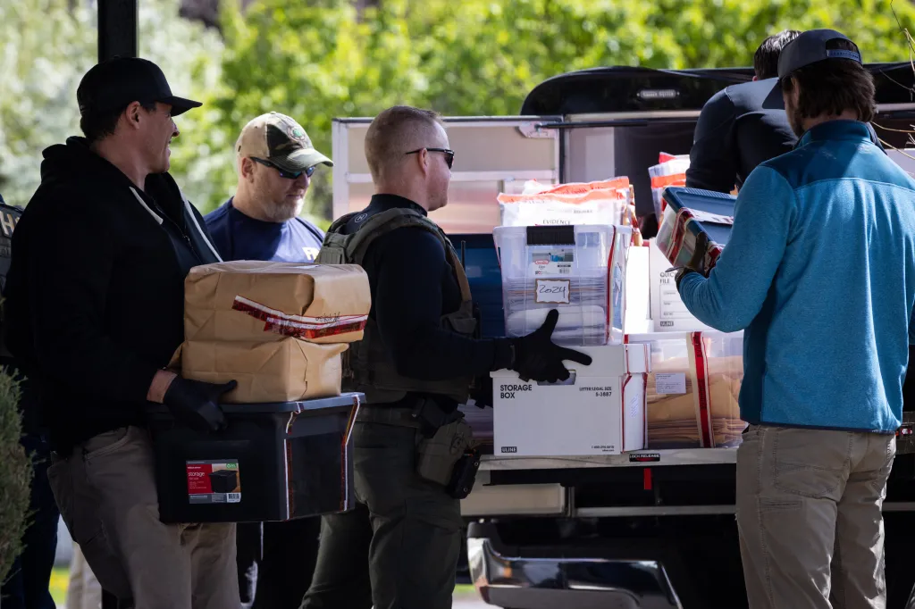 Federal and state officials load evidence into a vehicle.