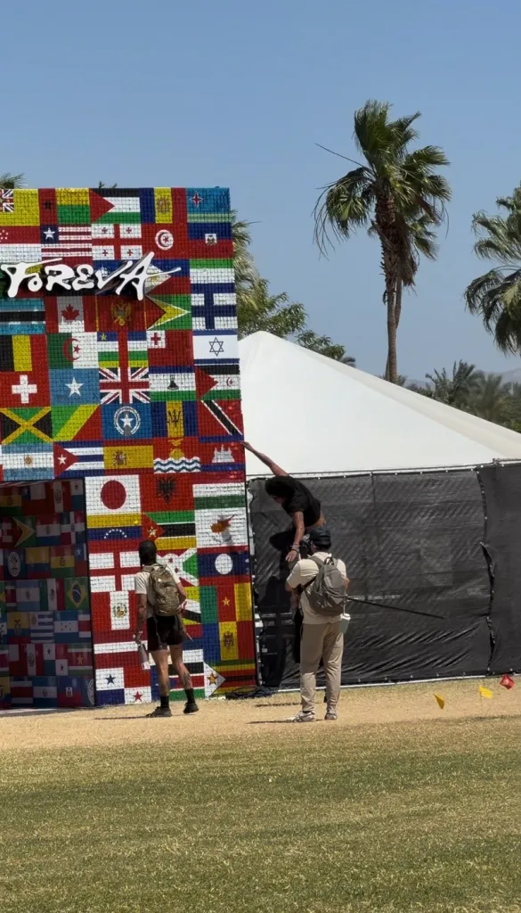 A festival attendee tries to rip off a flag from the Latina Foreva art installation at Coachella.