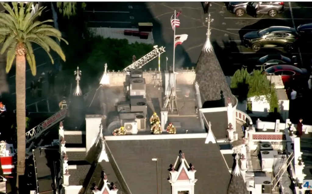 Aerial view of firefighters on the roof of the Magic Castle in Hollywood extinguishing a fire.
